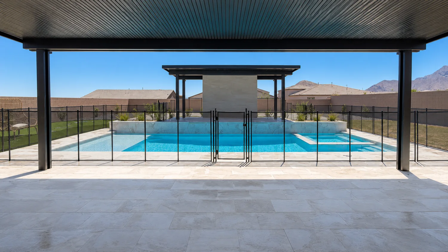 Black mesh pool fence surrounding a modern Las Vegas backyard pool and spa